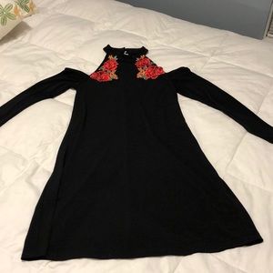 Black dress with open shoulders and long sleeves and coral appliqués on front
